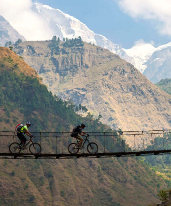 Zwei Radfahrer fahren über eine Hängebrücke