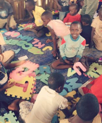 Viele Kinder spielen auf dem Boden mit Schaumstoffbuchstaben