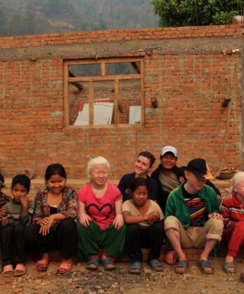 Kinder sitzen vor Baustelle in Swaragau