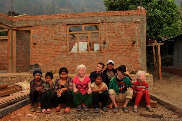 Kinder sitzen vor Baustelle in Swaragau