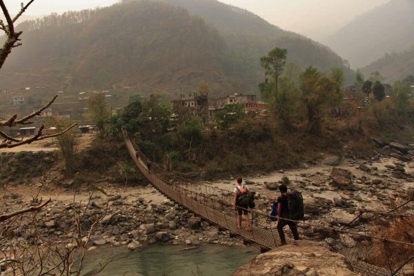 Reisende gehen über Hängebrücke