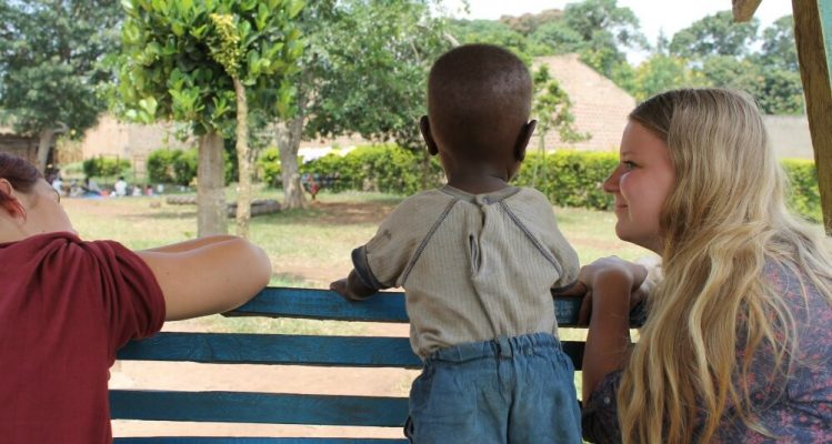 Volontäre mit Kind in Uganda