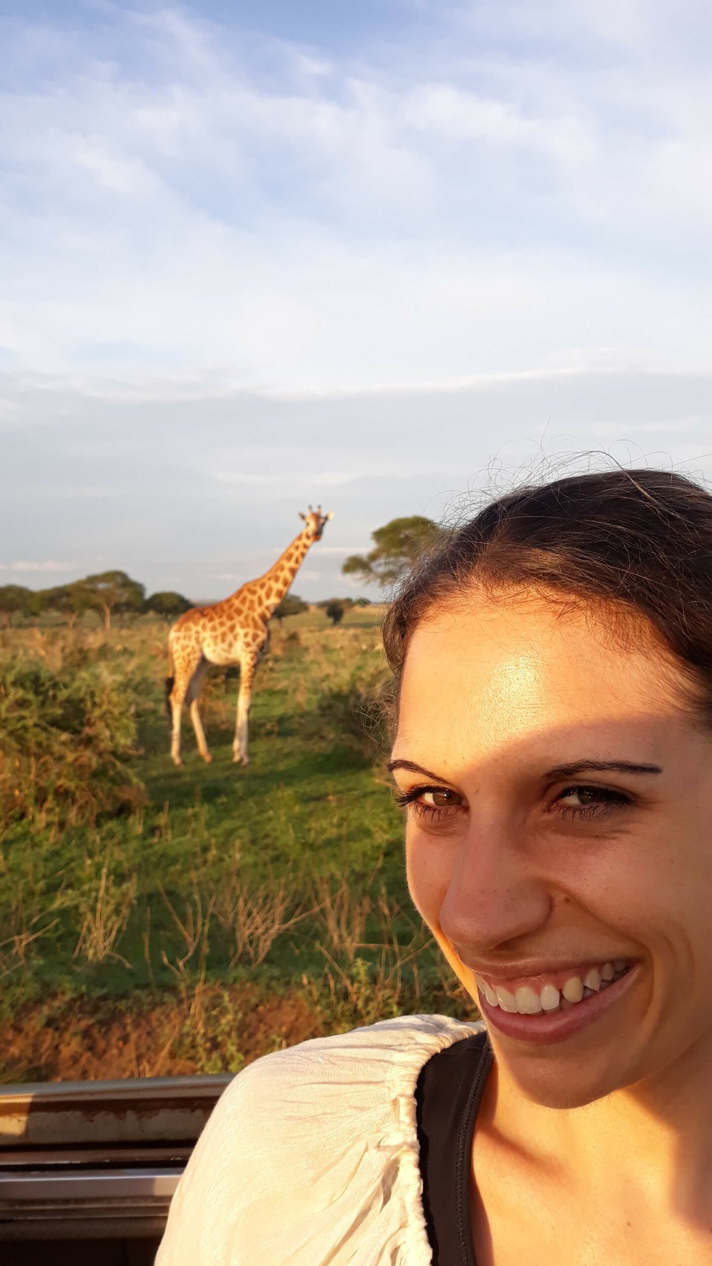 Reisende mit Giraffe im Hintergrund