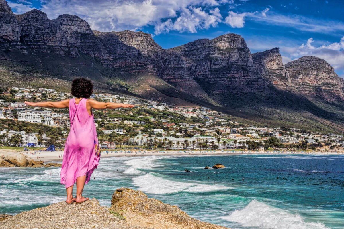 Frau mit ausgestreckten Armen in Camps-bay, Kapstadt, Südafrika