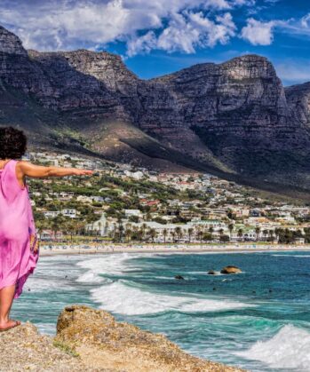Frau mit ausgestreckten Armen in Camps-bay, Kapstadt, Südafrika