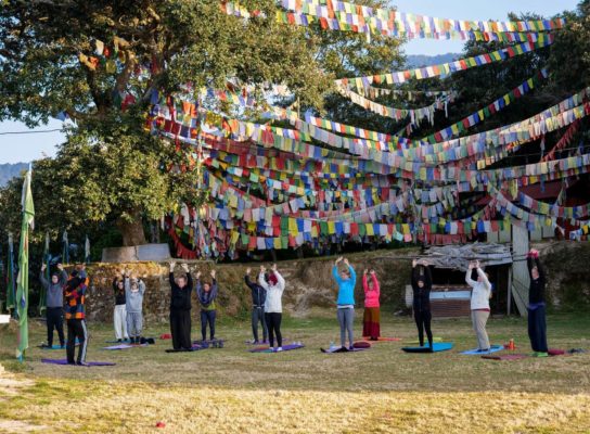 Reisende praktizieren Yoga im Kloster in Nepal
