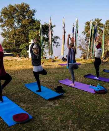 Reisende praktizieren Yoga im Kloster in Nepal