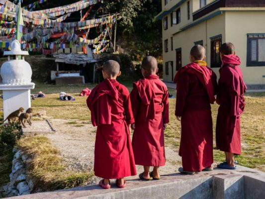 Nonnen beobachten Gruppe von Reisenden beim Yoga