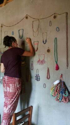 Volontärin dekoriert Wand mit Ketten in Uganda