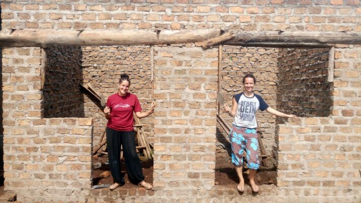 Zwei Volontärinnen stehen in neuem Haus in Uganda