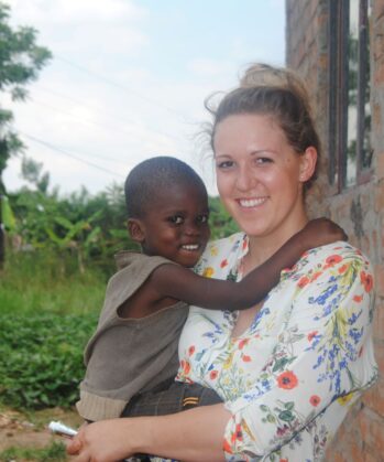 Volontärin mit fröhlichem Kind in Uganda