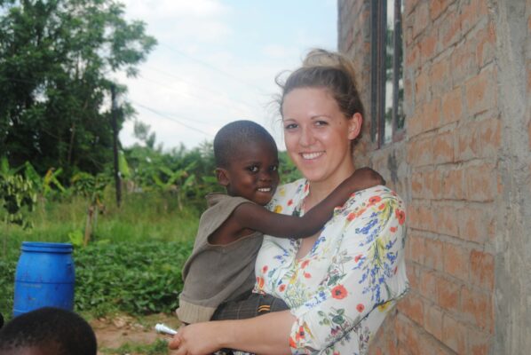 Volontärin mit fröhlichem Kind in Uganda