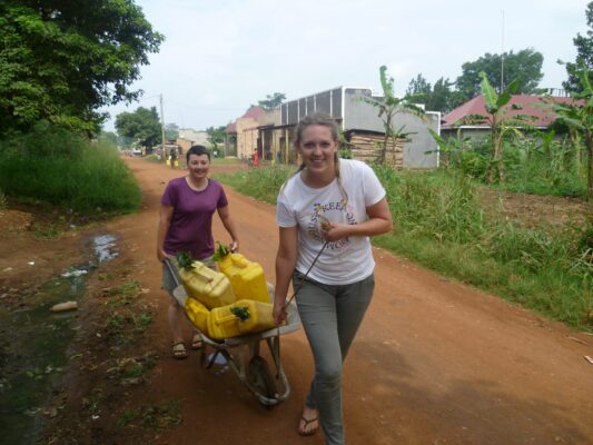 Freiwillige transportieren Wasserkanister in Uganda