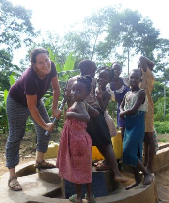 Freiwillige und Kinder beim Brunnen in Uganda