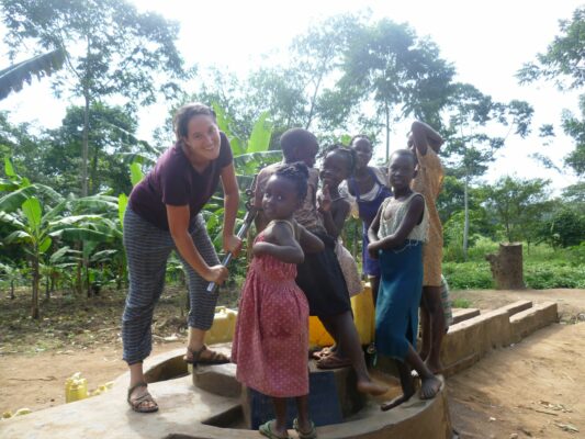Freiwillige und Kinder beim Brunnen in Uganda
