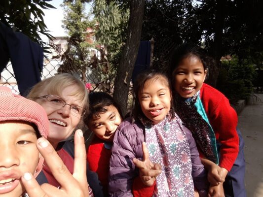 Volontärin mit Kindern im Sozialprojekt in Nepal