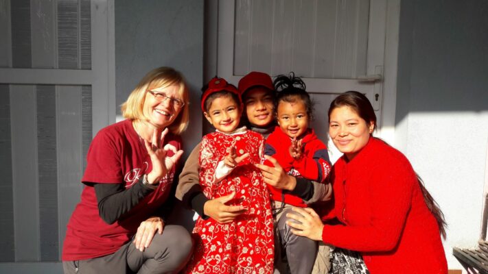 Volontärin mit Einheimischen im Bergdorf Nepal