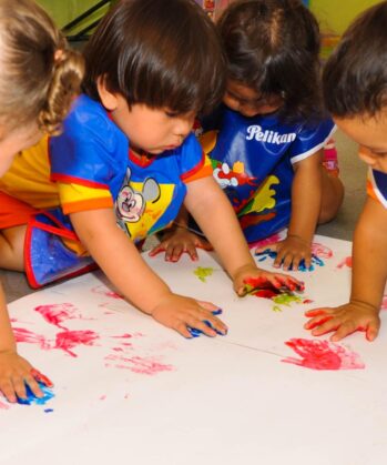 Kinder machen Handabdruck auf großes Papier