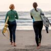 Zwei Frauen mit Surfbrett unter den Armen